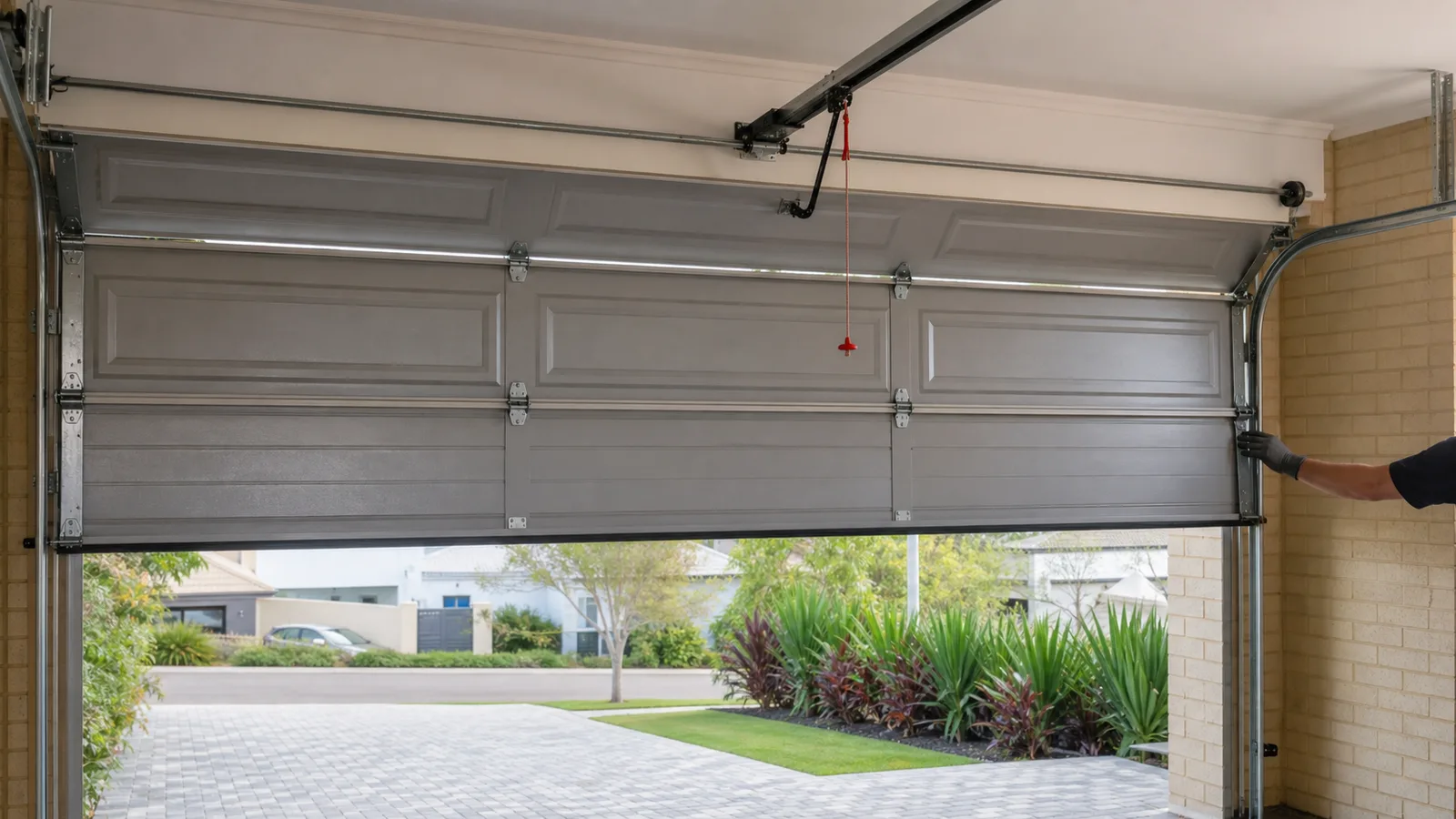 Technician checking garage door balance by hand at the halfway point
