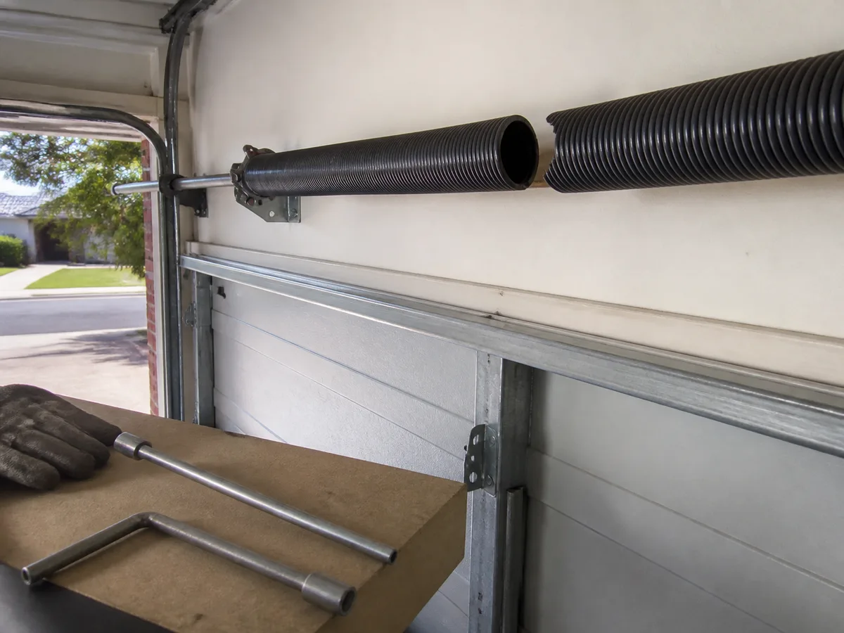 Broken torsion spring above a garage door, showing the visible gap in the coil